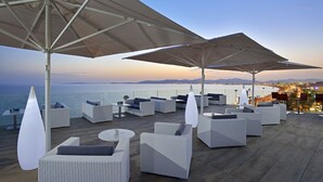 Una terraza en la azotea con mobiliario exterior y vistas al mar.