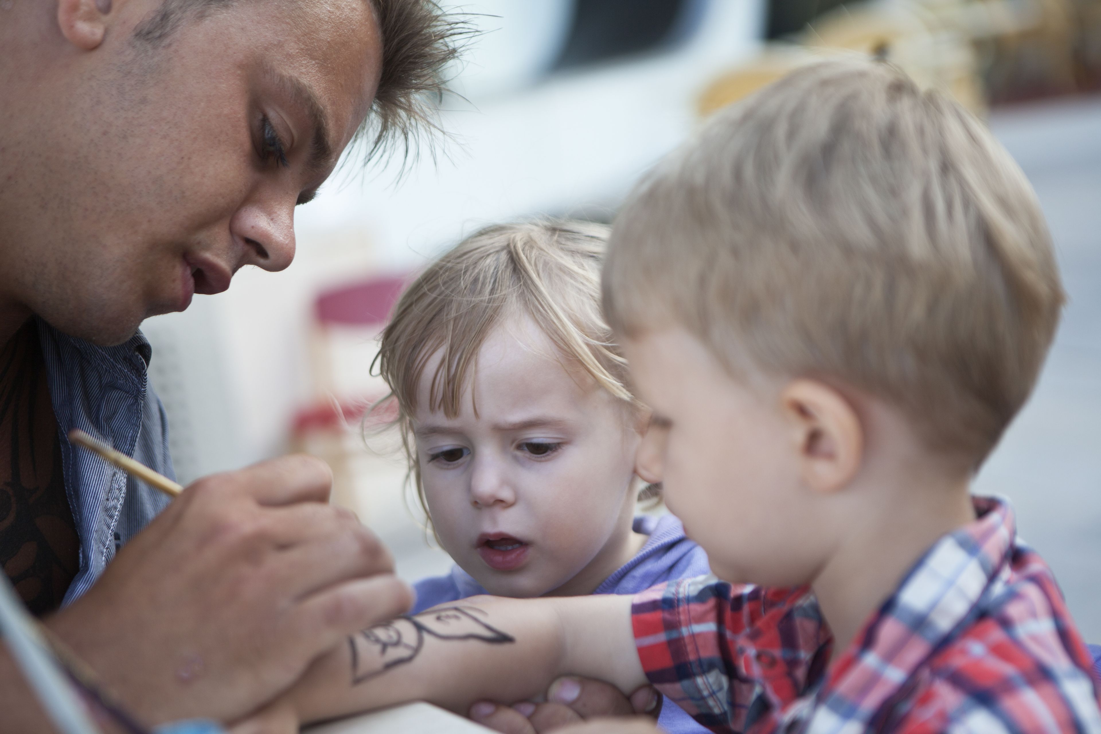 A person drawing on another person's arm.