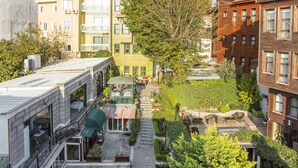 A courtyard with outdoor seating, surrounded by multi-story buildings with balconies and windows. - Garden House Hotel - Special Class (Istanbul)