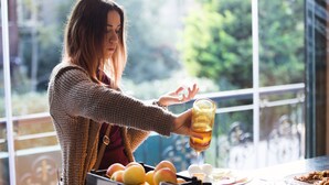 A person pouring a drink from a bottle at a counter with fruits and eggs nearby. - Garden House Hotel - Special Class (Istanbul)