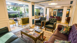 A spacious lobby with leather seating, a coffee table with magazines, and a view of the outdoor area. - Garden House Hotel - Special Class (Istanbul)
