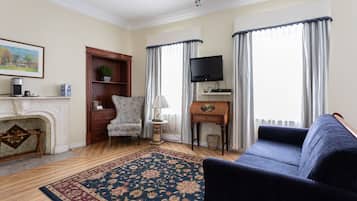 A living room with a fireplace, a sofa, a television, and a rug.