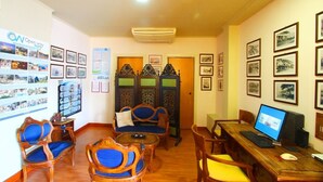 A room with a wooden desk, computer, and several chairs. There are framed pictures on the walls and a bulletin board with various items pinned to it. - Mantas Seaside Boutique Hotel (Loutraki-Agioi Theodoroi)