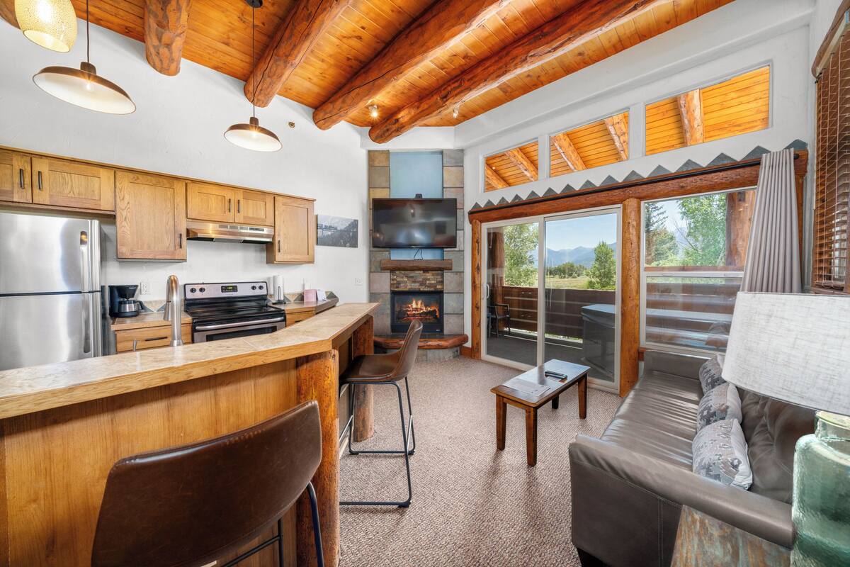A modern kitchen with wooden cabinets, a stainless steel refrigerator, and a built-in stove.