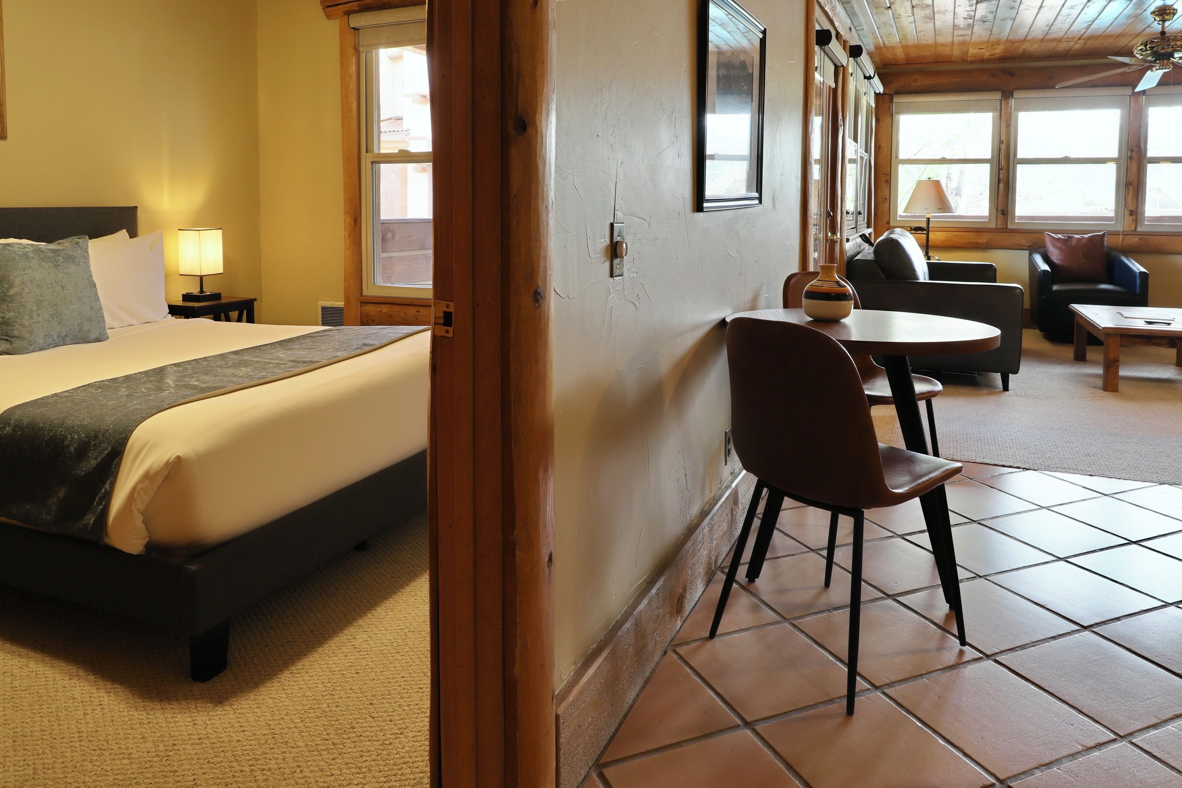 Une chambre d’hôtel avec un lit, une table à manger, une chaise et un canapé.