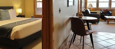 Une chambre d’hôtel avec un lit, une table à manger, une chaise et un canapé.
