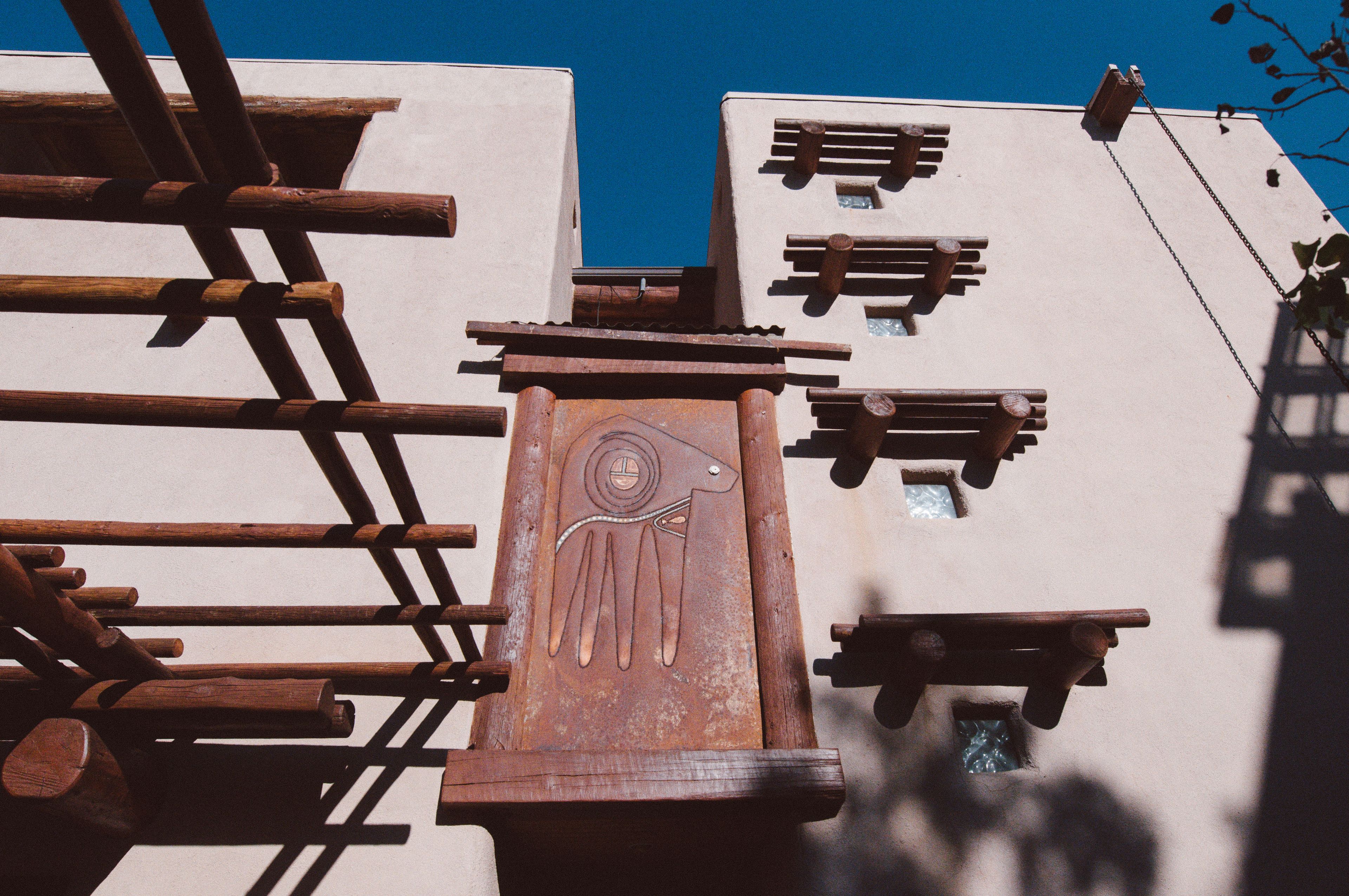 A building with a unique architectural design featuring wooden beams and a prominent hand symbol.