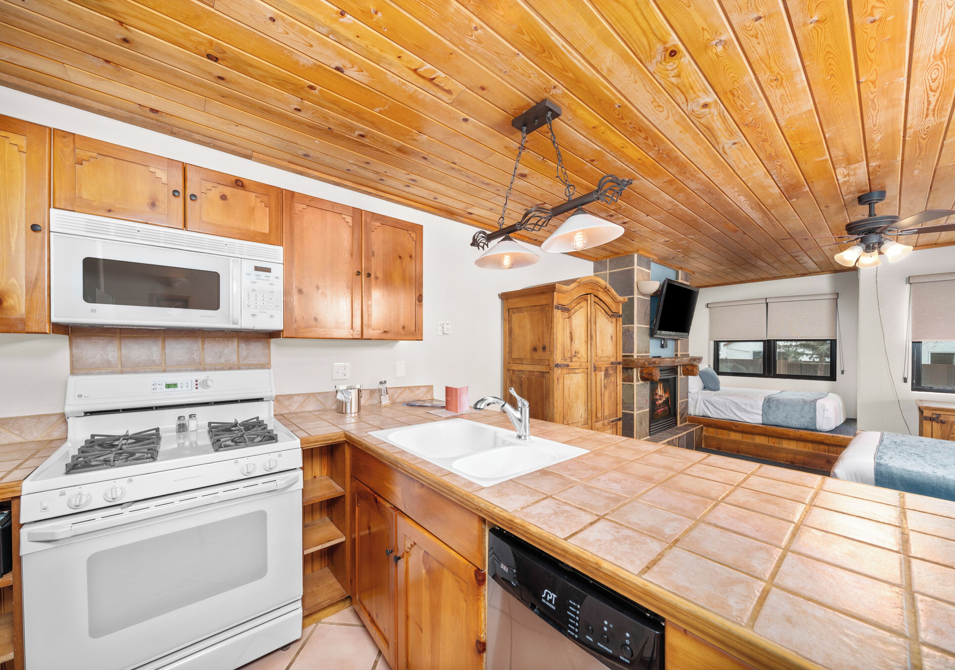 Une cuisine avec des meubles en bois, un four à micro-ondes, une cuisinière et un lave-vaisselle.
