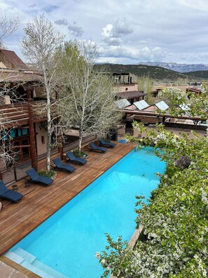 Relax by the resort's pool surrounded by comfortable loungers and scenic views of rolling hills and mountains.