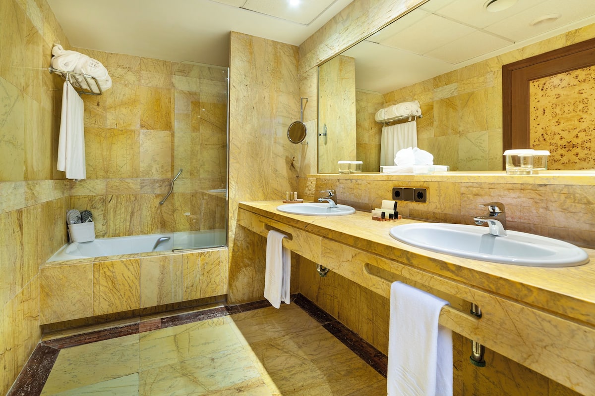 Une salle de bain moderne avec deux lavabos, une baignoire et une douche.