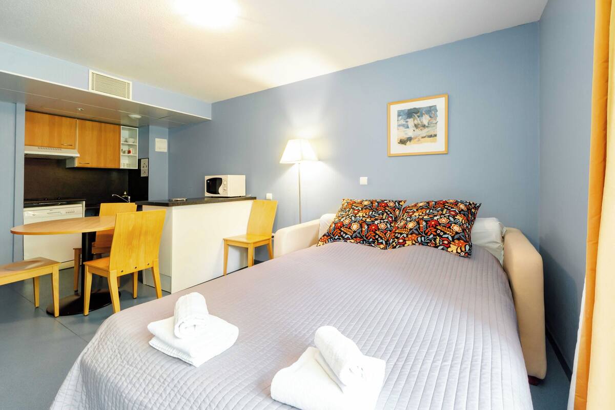 Une chambre d’hôtel équipée d’un lit, d’un bureau, d’une chaise et d’un four à micro-ondes.