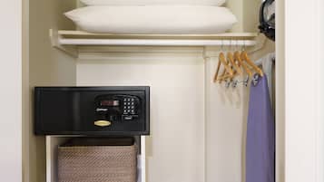 A closet with a black appliance, wooden hangers, and a purple garment.