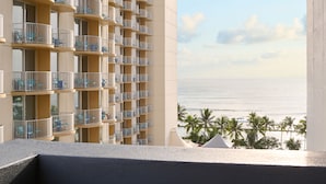 A high-rise hotel with multiple balconies, each with a railing and a view of the ocean. - Hotel Renew (Honolulu)