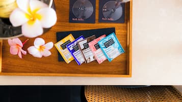 A wooden tray with a selection of Hawaiian-themed gift cards, two wine glasses, and a few flowers.