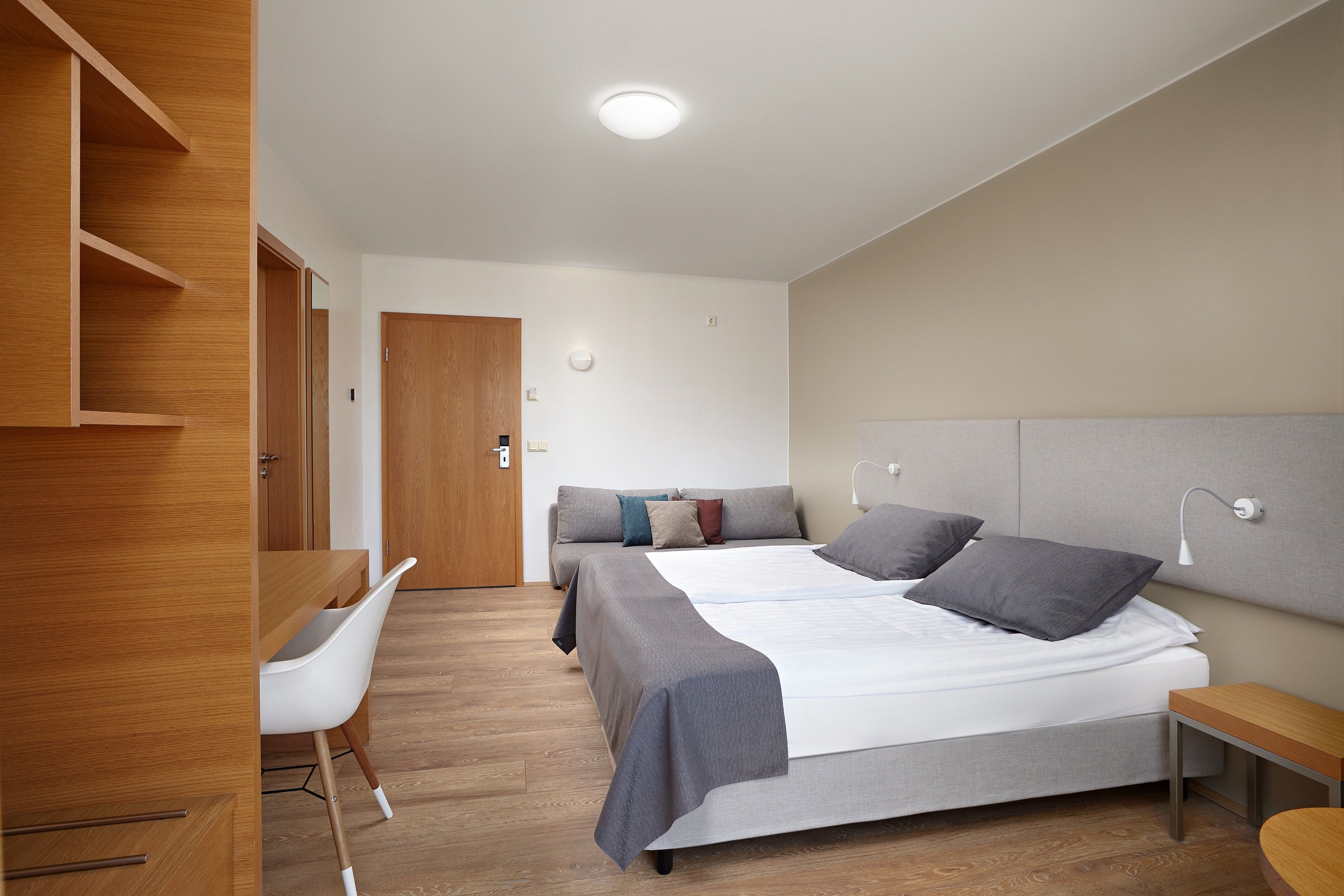 Un dormitorio moderno con una cama grande, un escritorio y una silla.