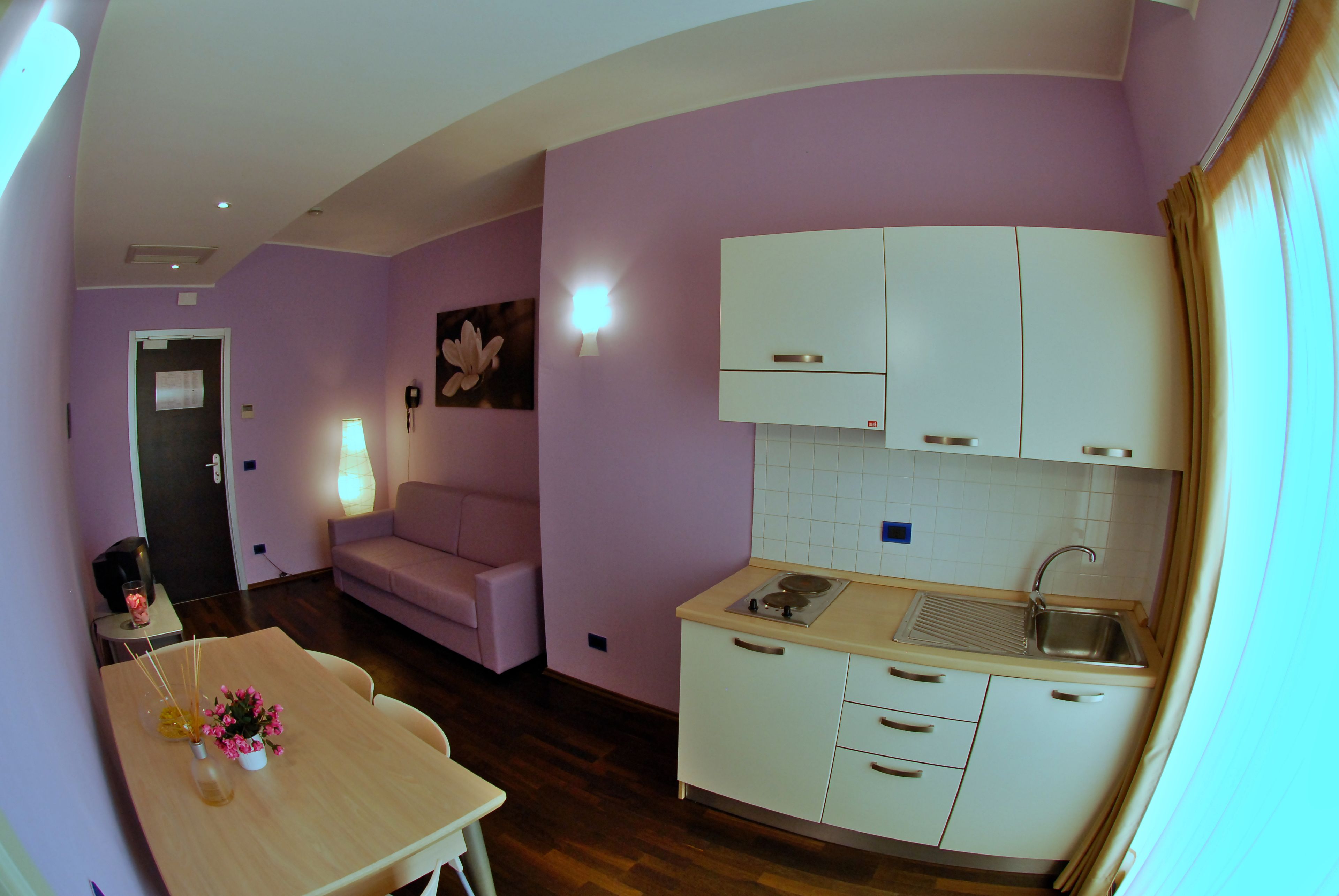 A compact living space with a kitchenette, a dining area, and a seating area.