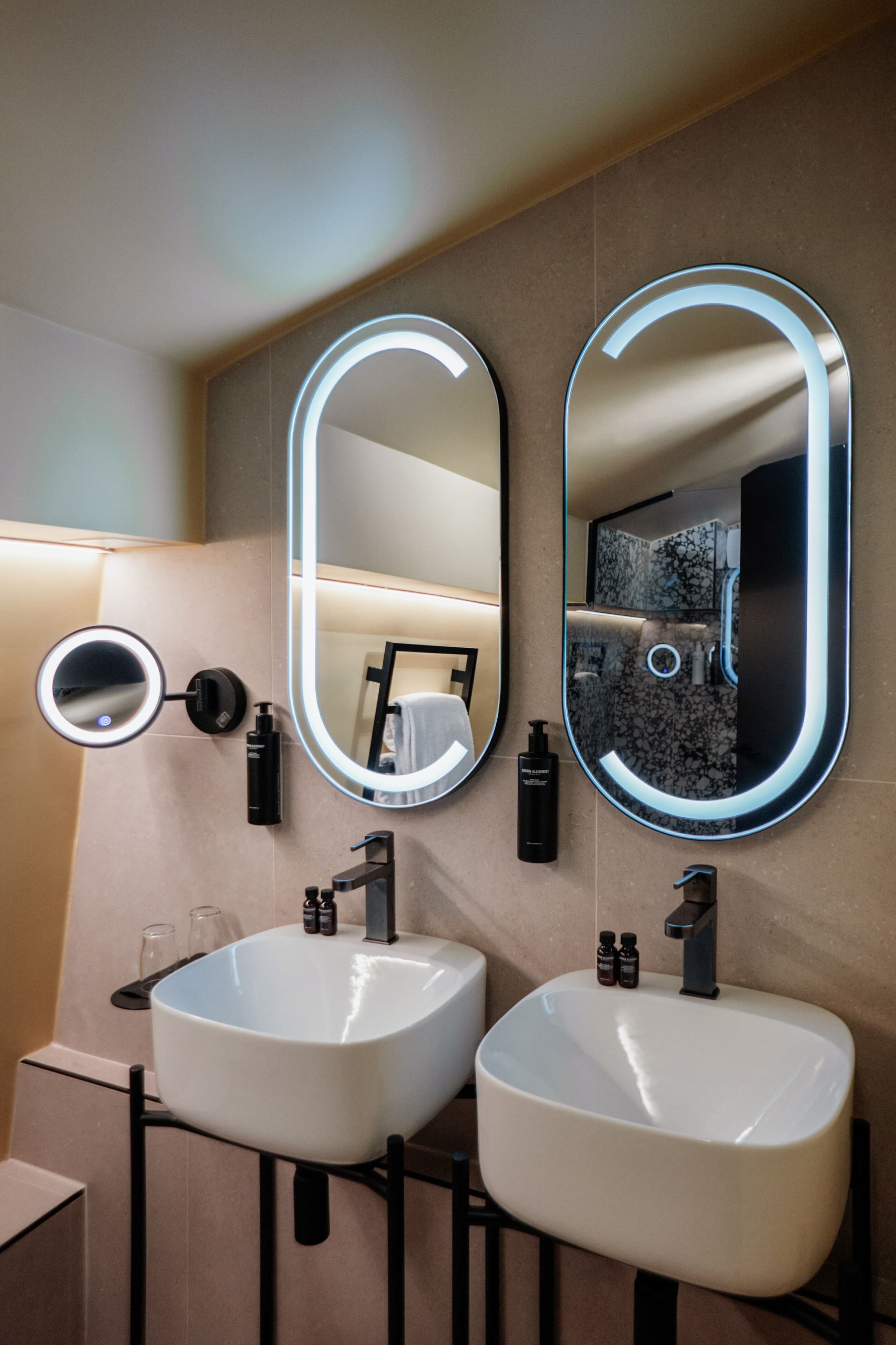 A bathroom with two sinks, a mirror, and a towel rack.