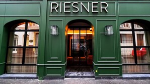 Un edificio verde con el nombre 'RIESNER' en su entrada.