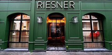 A green building with the name 'RIESNER' above the entrance.