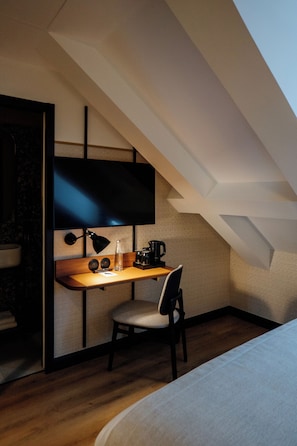 Una habitación pequeña con escritorio, silla y cama.