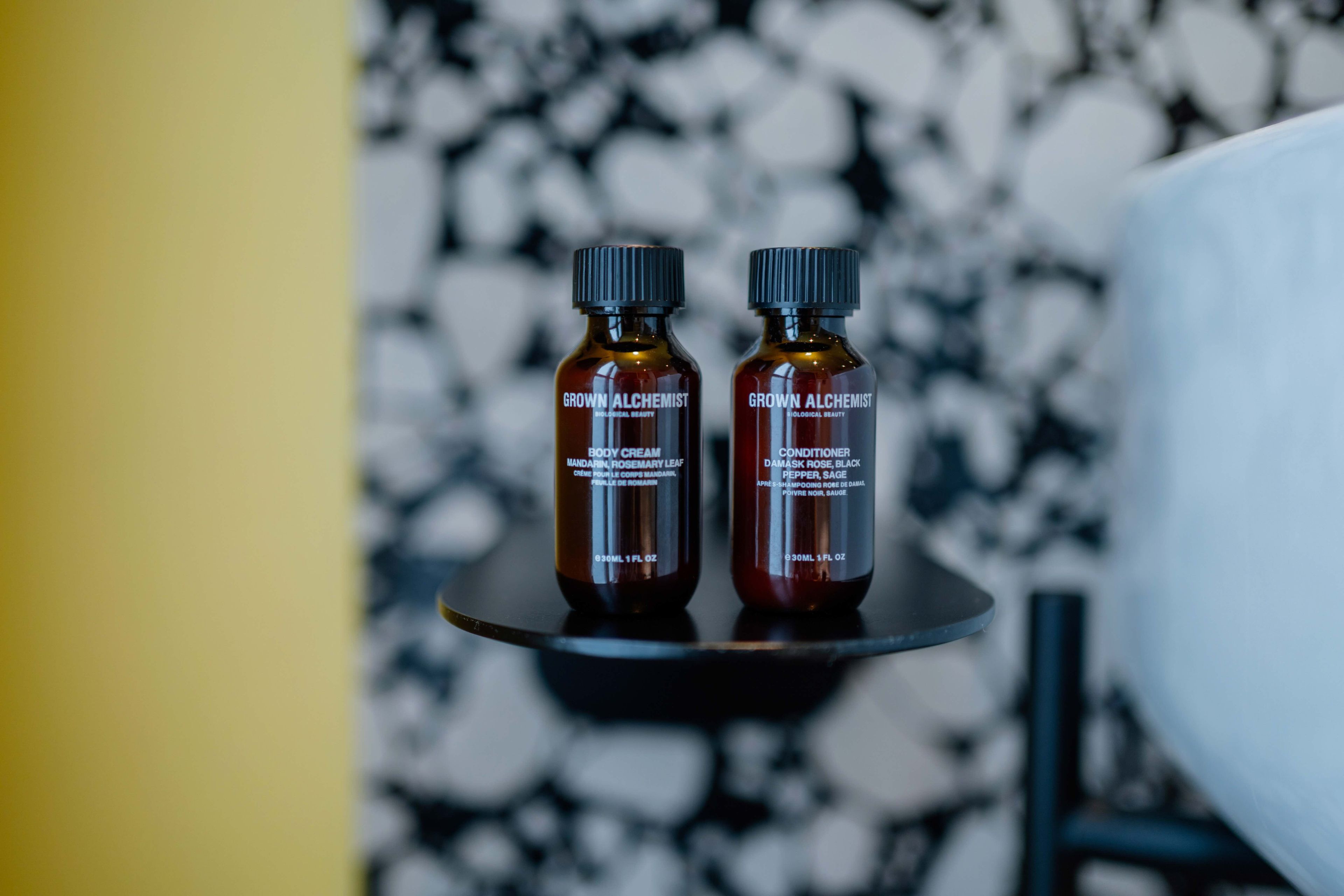 Dos botellas de productos 'Grown Alchemist' sobre una bandeja negra.