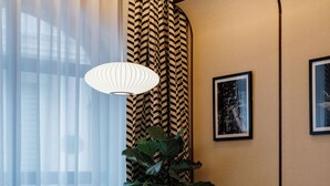 Una sala de estar moderna con dos sillones, una mesita redonda y una planta grande.
