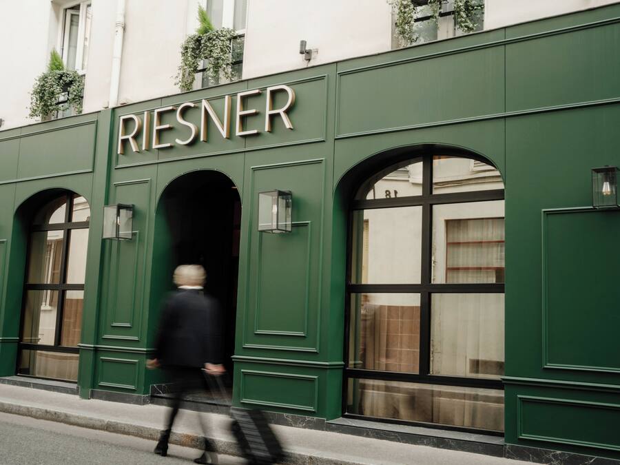 Un edificio con el nombre 'RIESNER' claramente visible sobre la entrada.