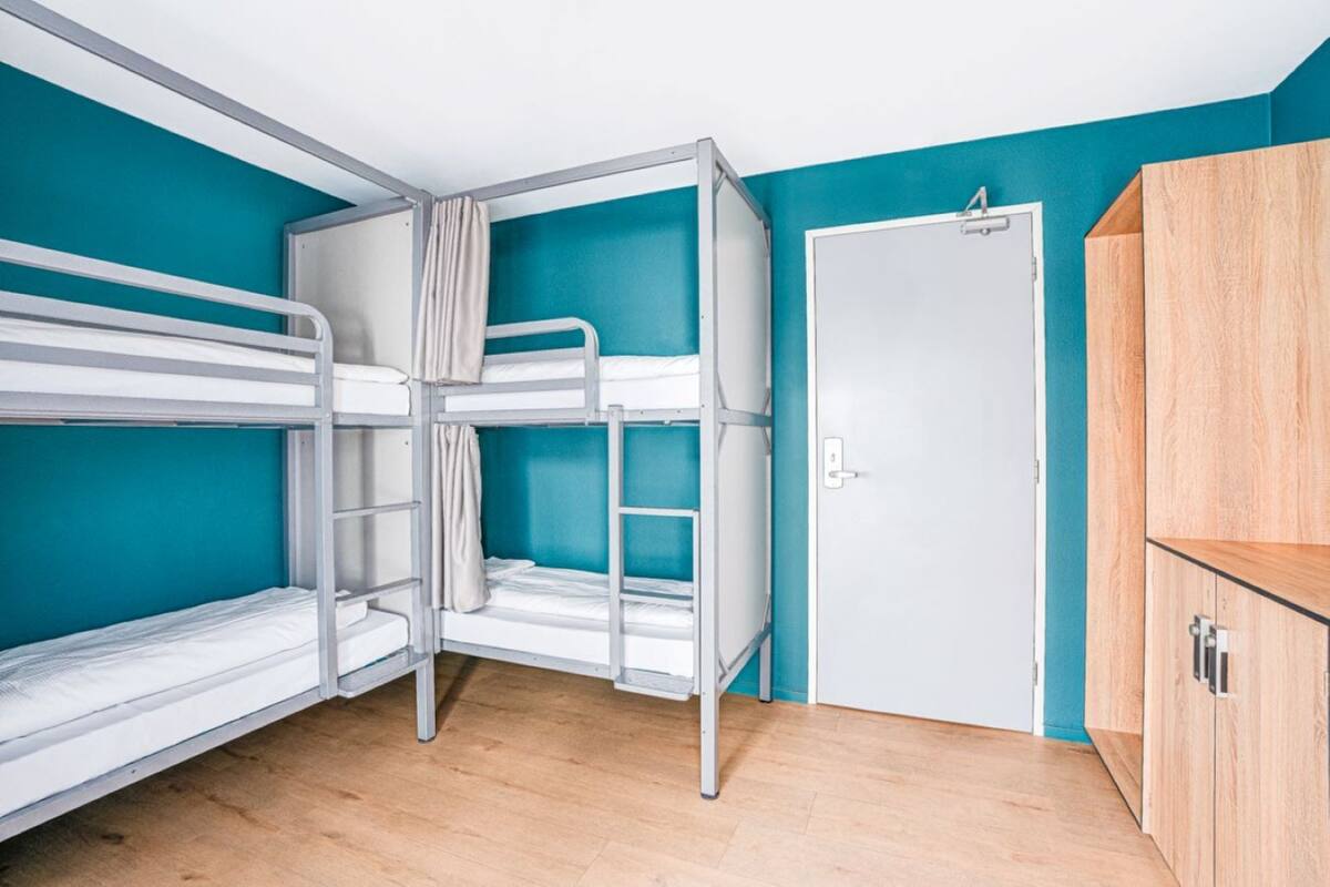 A room with bunk beds, a wardrobe, and a door.