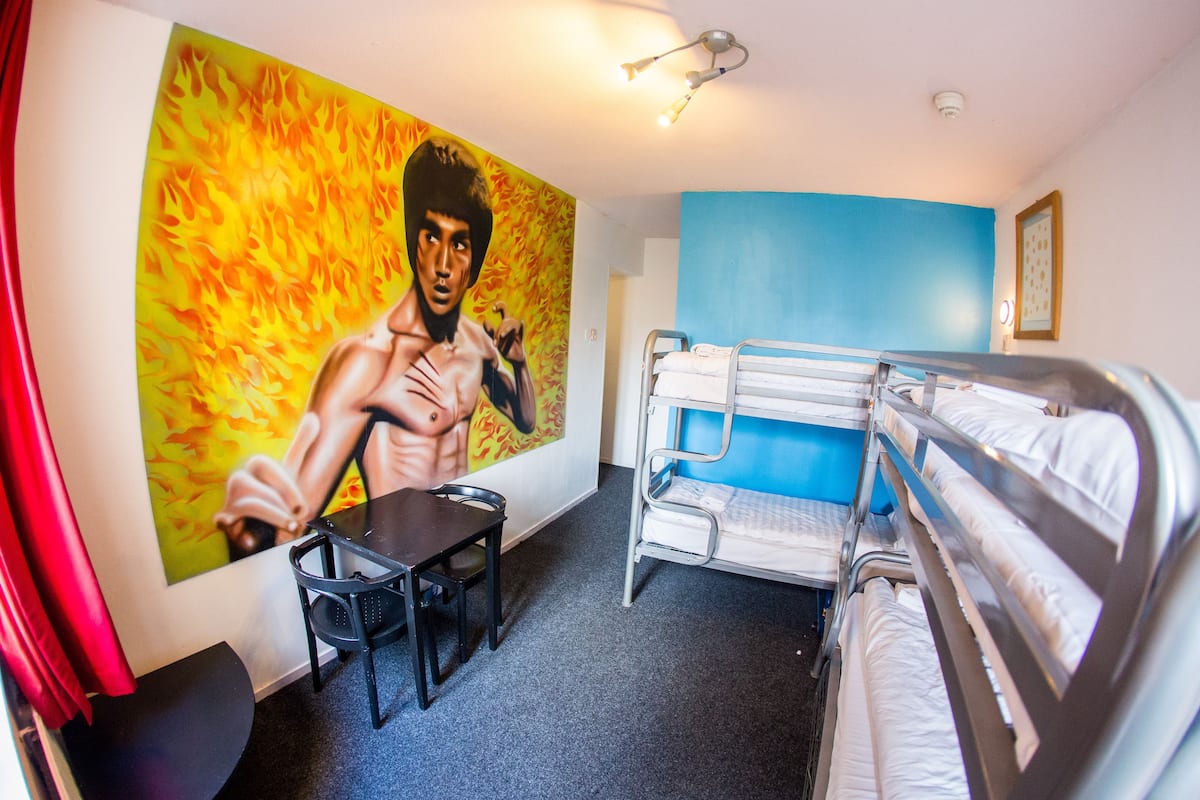 A room with bunk beds, a desk, and a chair.