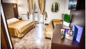 A hotel room with a bed, a desk, a mirror, and a window with curtains. - D'este (Rome)