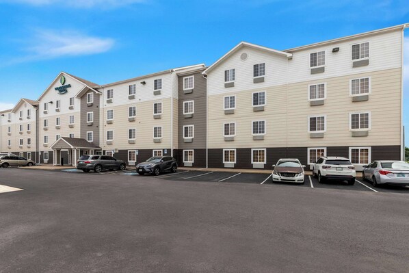 A multi-story hotel with a parking lot in front.