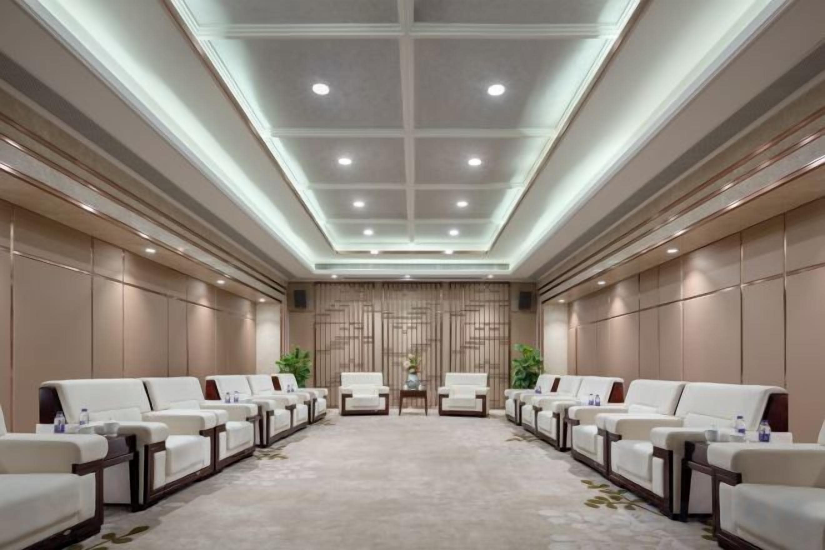 A conference room with a long table, multiple chairs, and a carpeted floor.