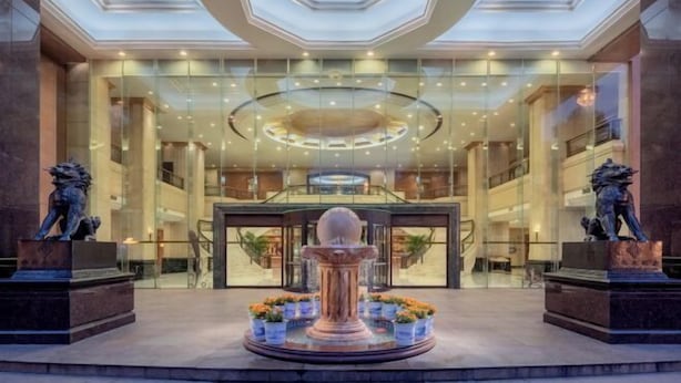 A spacious lobby with a central fountain, glass railings, and a modern ceiling design. - Changsha Jinyuan Yangguang Hotel (Wu Yi Square Helong Stadium) (Changsha)
