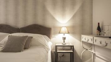 Un lit bien fait, avec des oreillers, une table de chevet avec une lampe et une commode avec des tiroirs.
