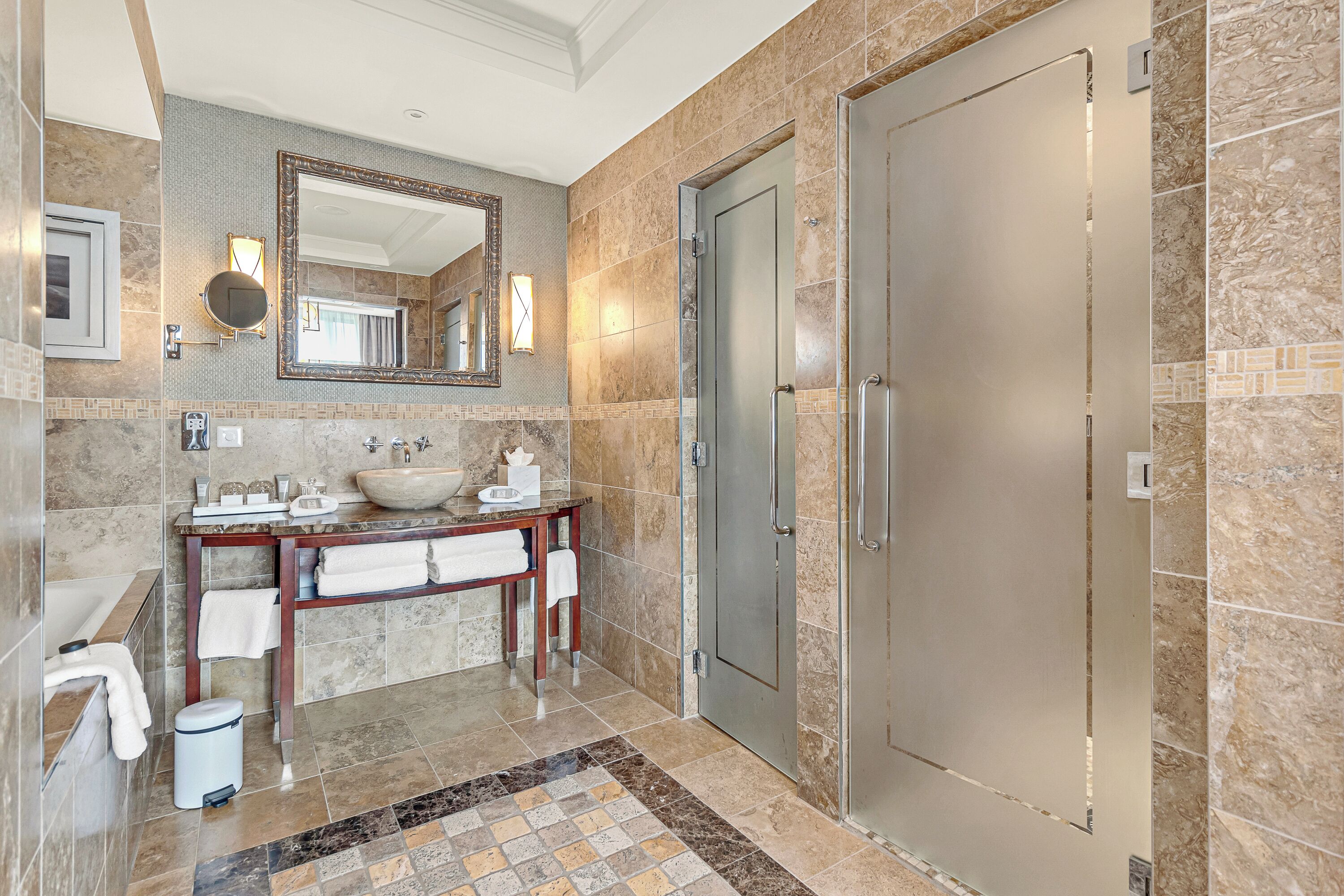 A modern bathroom with a large mirror, a sink, and a shower.