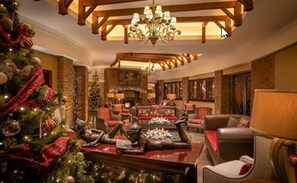 A warmly decorated lobby with a Christmas tree, plush seating, and a fireplace. - Fota Island Hotel & Spa (Fota)