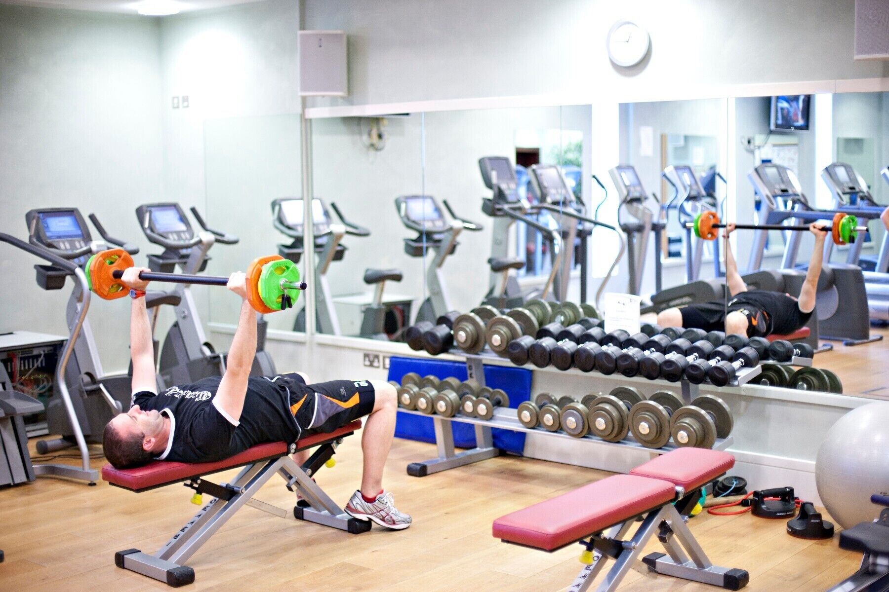 Ein Fitnessstudio mit Trainingsgeräten, Laufbändern und Kurzhanteln.
