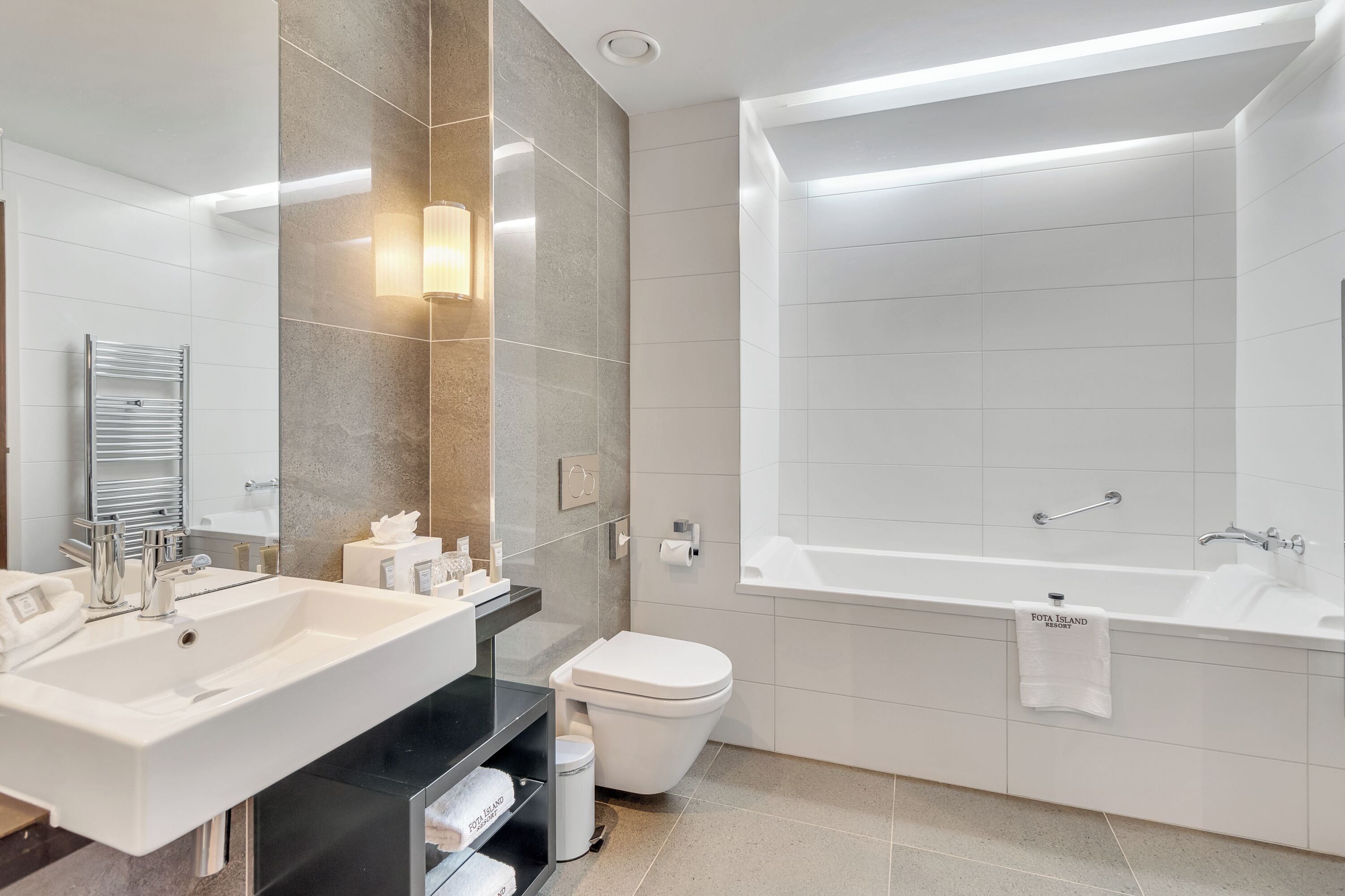 A modern bathroom with a large sink, toilet, and bathtub.