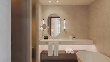 Un bagno moderno con una vasca freestanding, uno specchio grande e un mobile lavabo con due lavandini.