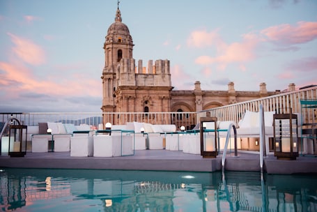 Una piscina al aire libre, sillones reclinables de piscina