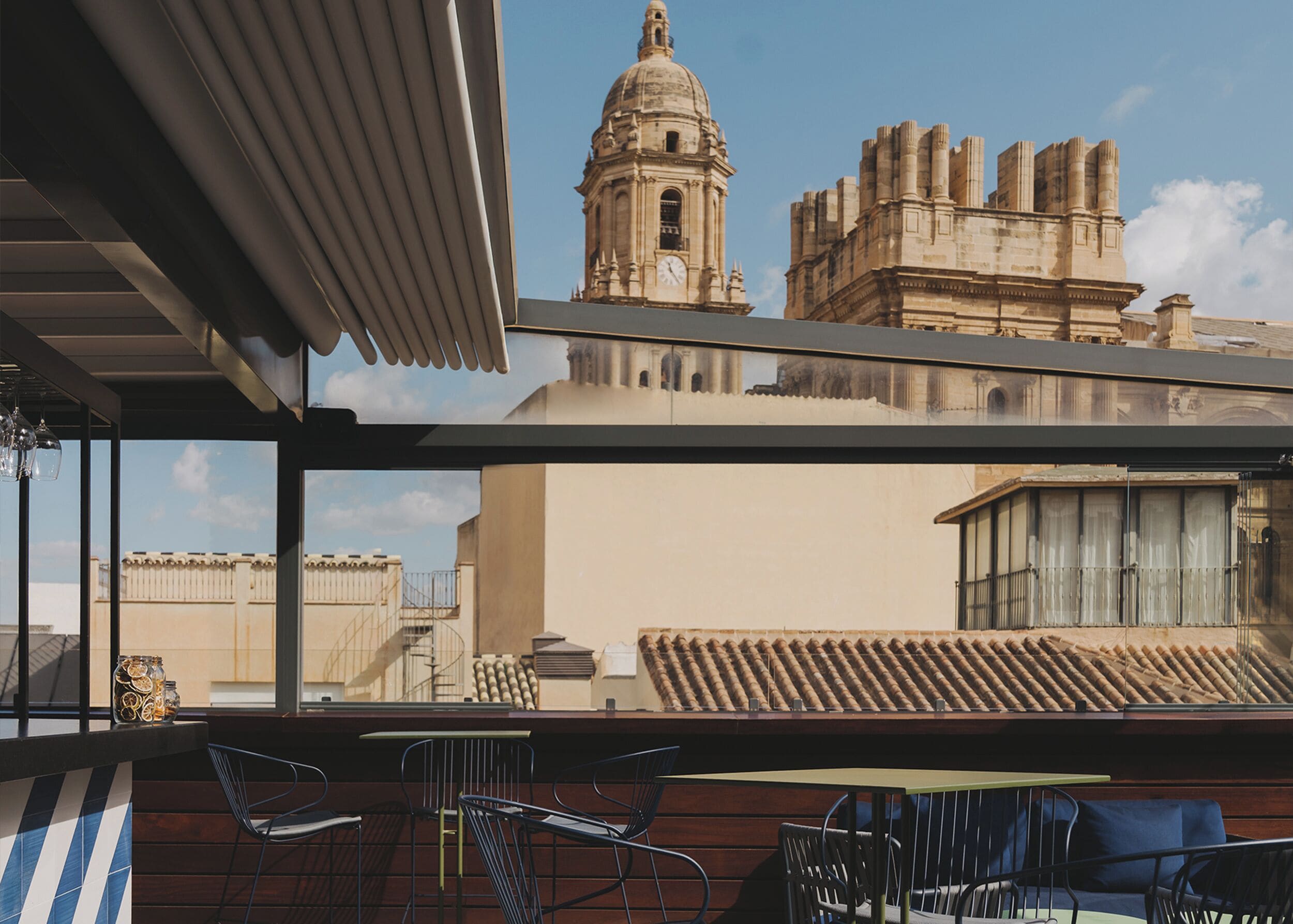 A rooftop terrace with a view of a historic building, including a clock tower and domed structure.
