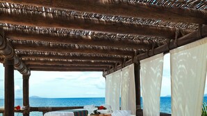 Une chambre avec deux lits, un jacuzzi et vue sur la mer.