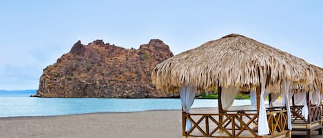 Na praia, espreguiçadeiras, guarda-sóis, massagens na praia 