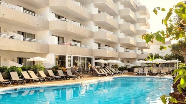 A hotel with a swimming pool, sun loungers, and umbrellas. - Coral California (Arona)