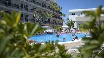 Una piscina al aire libre, tumbonas