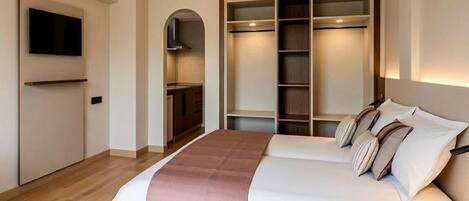 Une chambre d’hôtel équipée d’un lit, d’une télévision, d’une armoire et d’une kitchenette.