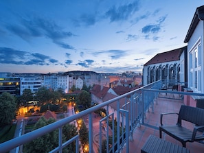 A balcony with a view of a cityscape, including buildings and a church.