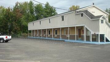 A motel with a covered parking area and a single-story building with a flat roof.