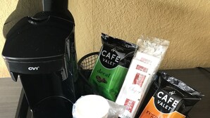 A tray with a coffee maker, decaf and regular coffee bags, a milk jug, and a sugar packet. - Red Carpet Inn Orchard Park - Buffalo, NY (Orchard Park)