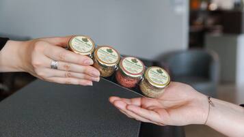 A person holding four jars of jam.